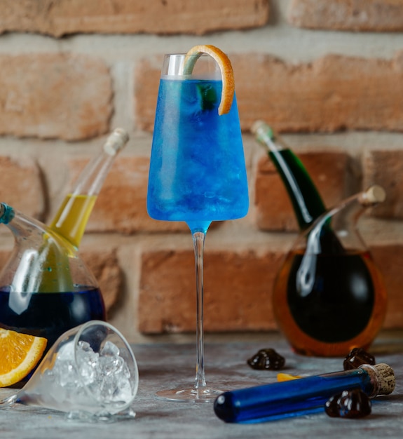 Cocktail au lagon bleu avec un bâton orange dans un verre