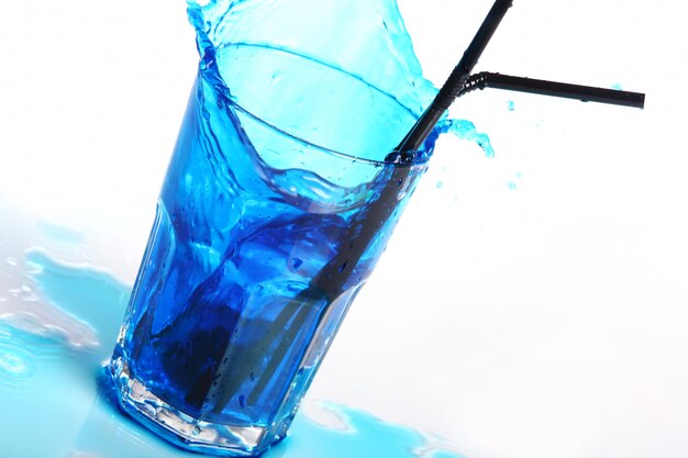 Cocktail bleu avec éclaboussures isolé sur blanc