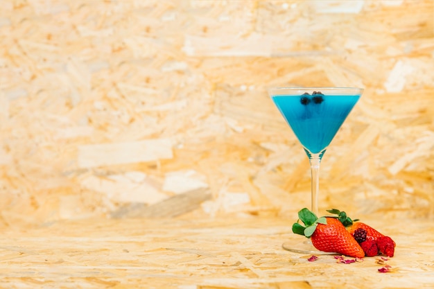 Photo gratuite cocktail bleu et fraises avec fond