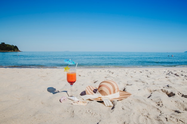 Cocktail et chapeau sur la plage
