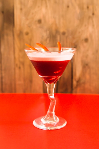 Cocktail frais dans un verre à martini sur un bureau rouge