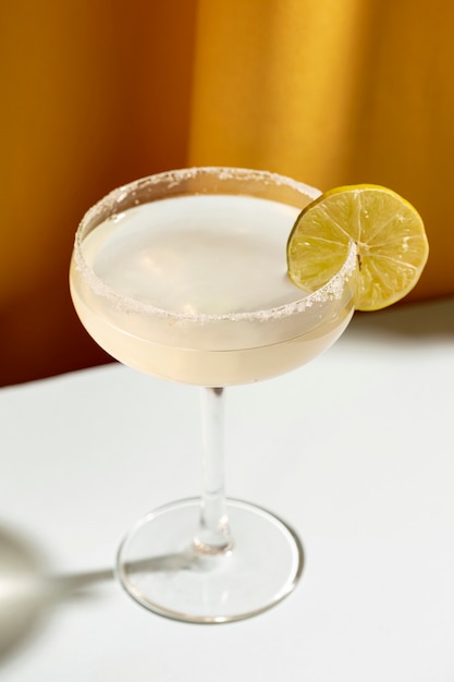 Cocktail garni de citron vert sur table blanche
