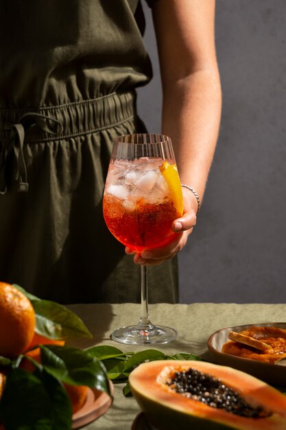 Cocktail italien à la main, nature morte