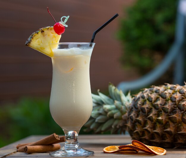 Cocktail laiteux en verre avec une tranche de pomme et une cerise.