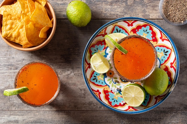 Cocktail michelada fait maison avec de la bière jus de citron vertsauce piquante jante salée et jus de tomate