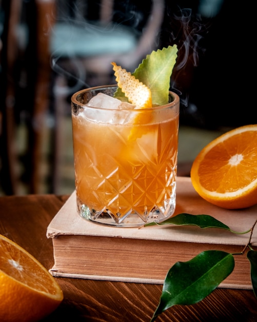 Photo gratuite cocktail d'orange avec de la glace sur la table