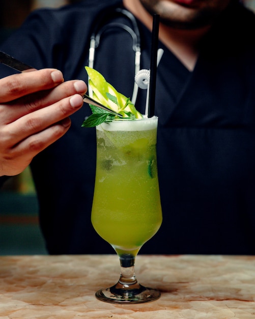 Cocktail de pomme verte garni d'une tranche de pomme verte et de menthe