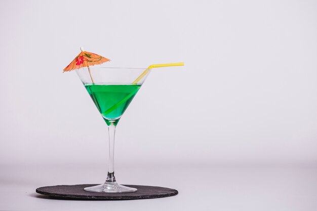 Cocktail vert avec parapluie et paille