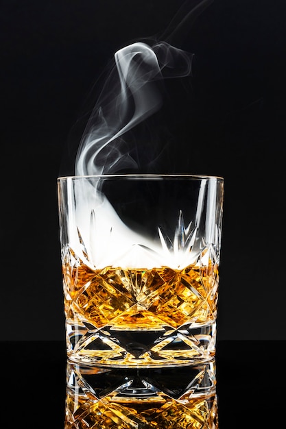 Photo gratuite cocktail de whisky fumé sur fond noir