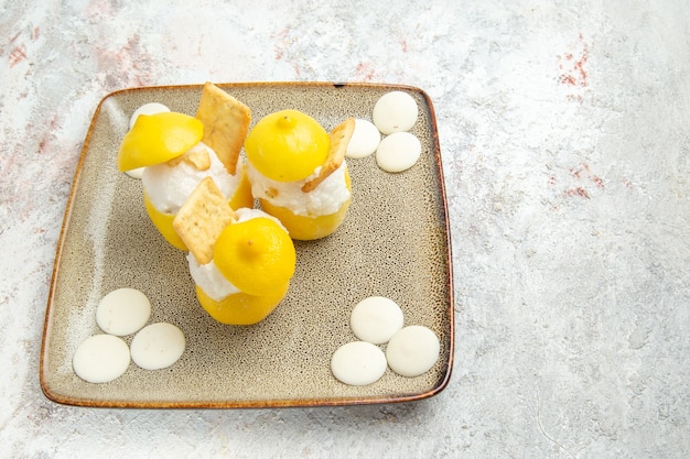 Cocktails Au Citron Vue De Face Avec Des Bonbons Blancs Sur Un Cocktail De Jus D'agrumes De Table Blanche