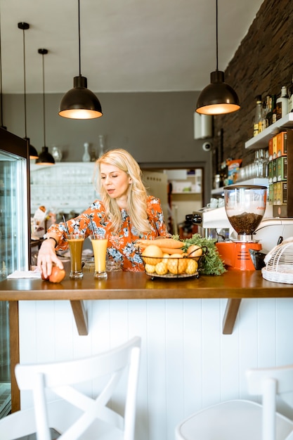 Photo gratuite cocktails sur le bar avec serveuse en arrière-plan