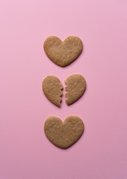 Coeur de biscuit brisé à plat sur fond rose