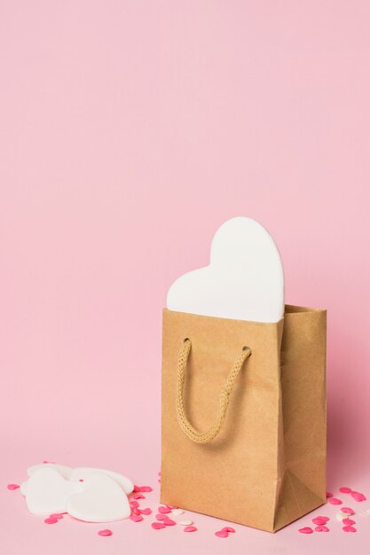 Coeur blanc dans un sac artisanal près de décorations
