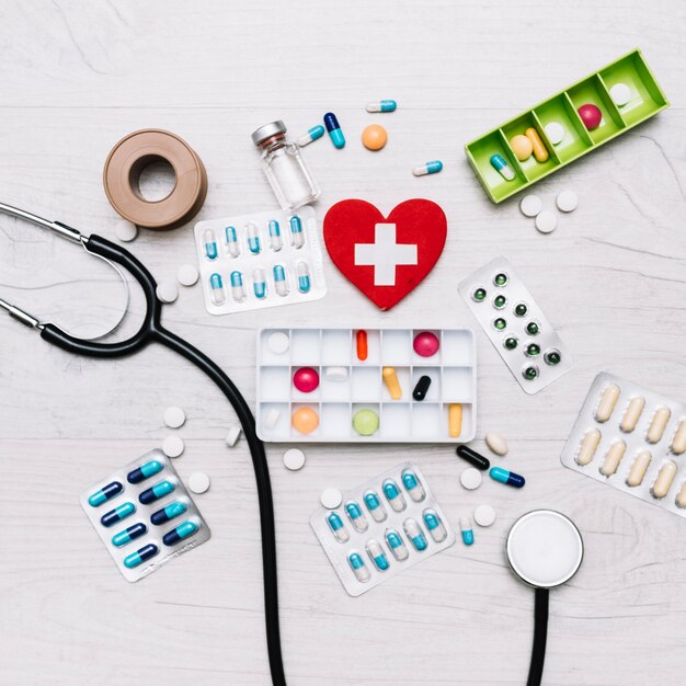 Coeur avec croix près du stéthoscope et des médicaments