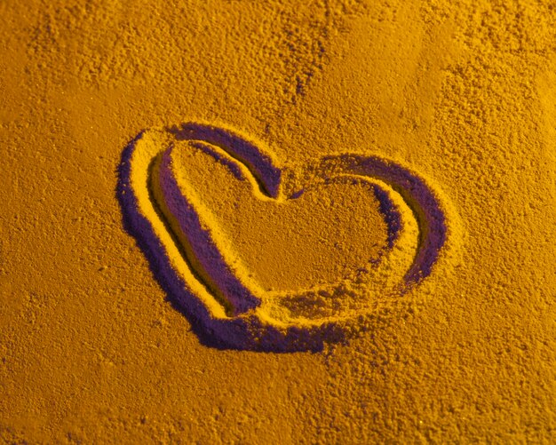 Coeur dessiné sur la texture de sable