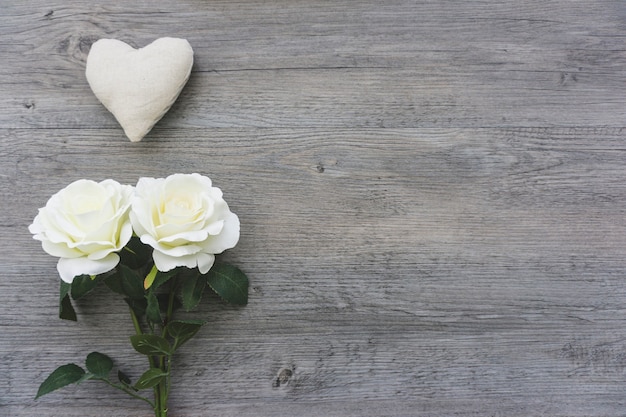 Coeur et fleurs blanches sur fond de bois