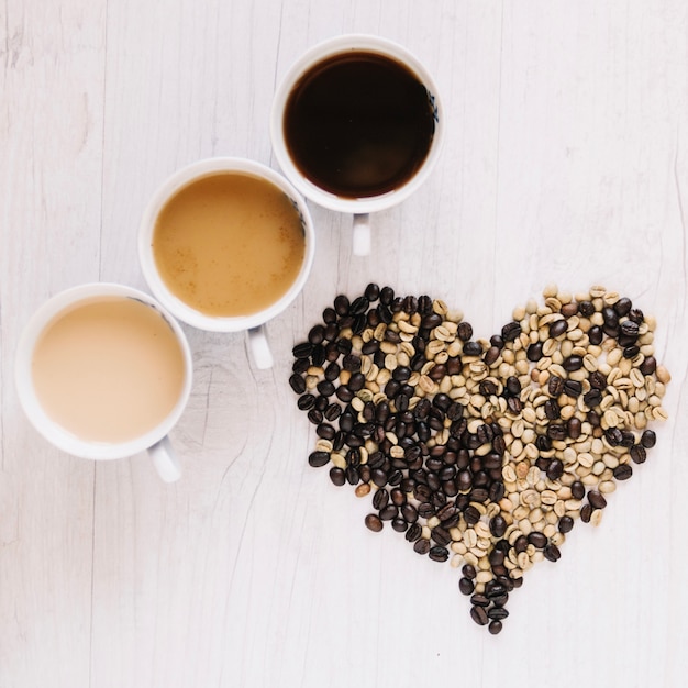 Coeur de grains de café près de tasses à café