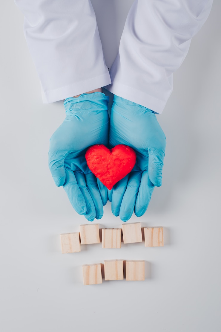 Photo gratuit coeur à l'intérieur des mains d'un homme avec des blocs de bois