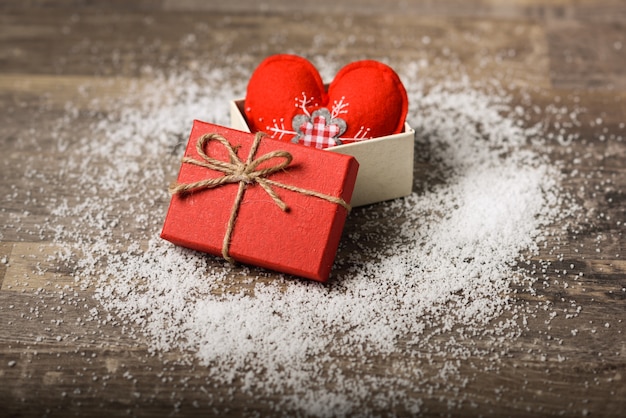 Photo gratuite coeur rouge dans une boîte cadeau sur planche de bois avec de la neige