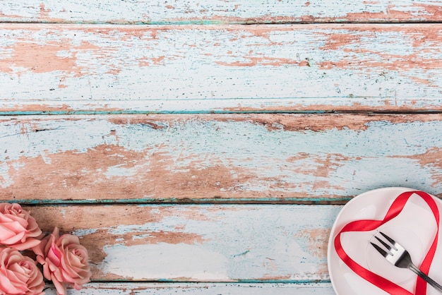 Coeur de ruban sur assiette avec des roses