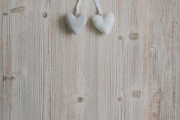 Coeurs suspendus à des cordes sur une surface en bois