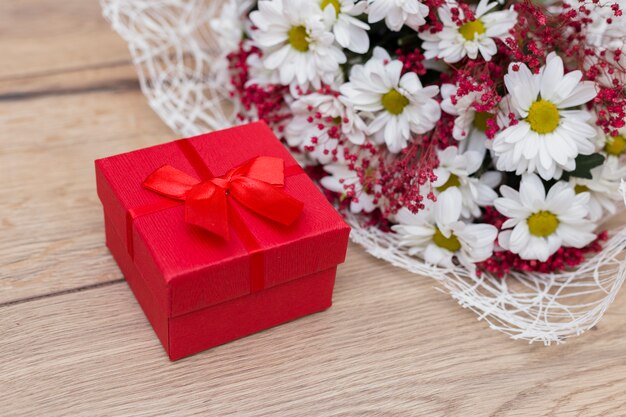 Coffret cadeau avec bouquet de fleurs sur la table