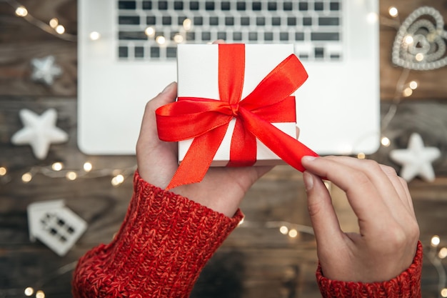 Photo gratuite coffret cadeau dans les mains des femmes et concept de magasinage de noël en ligne pour ordinateur portable