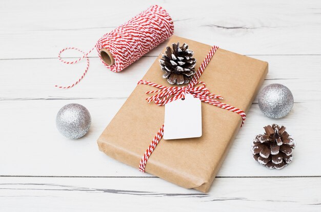 Coffret cadeau enveloppé près de boules et accrocs de Noël