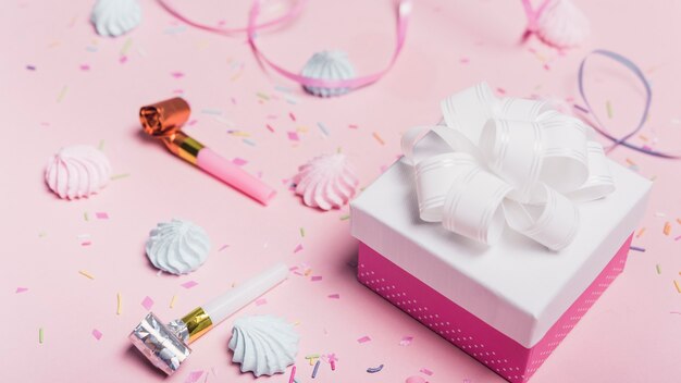 Coffrets cadeaux avec des bonbons; saupoudrer; curl ribbon et party blowers sur fond rose