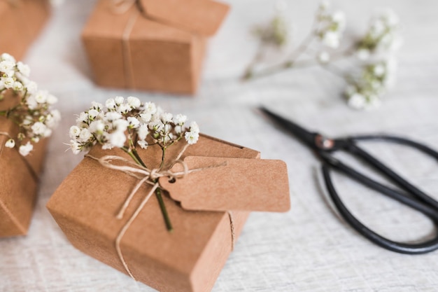 Coffrets-cadeaux en carton avec étiquette et fleurs d&#39;haleine de bébé sur un bureau en bois