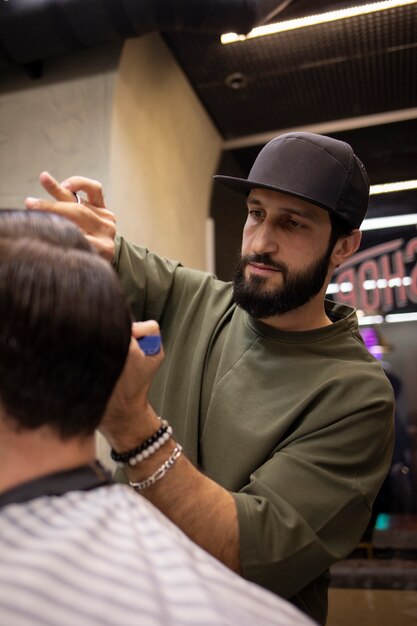 Coiffeur coupant les cheveux d'un homme au salon de coiffure