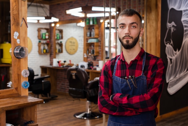 Coiffeur, dans, chemise rouge, regarder appareil-photo