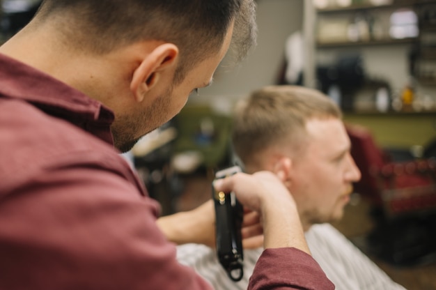 Coiffeur donnant une coupe de cheveux à un client