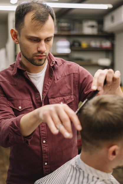 Coiffeur donnant une coupe de cheveux à un client