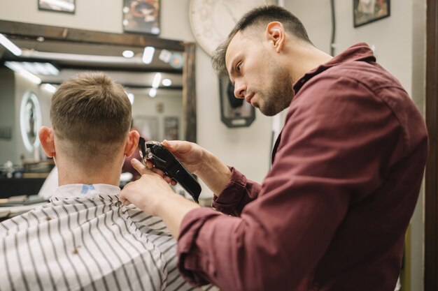 Coiffeur donnant une coupe de cheveux à un client