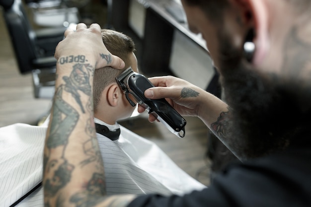 Coiffeur enfants coupe petit garçon sur un fond sombre.