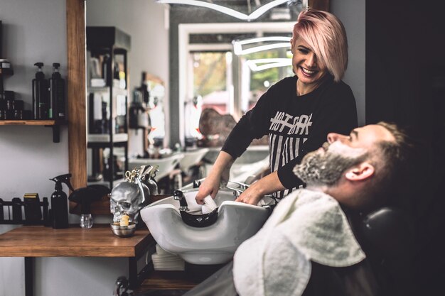 Coiffeur en gaieté et client préparant le traitement