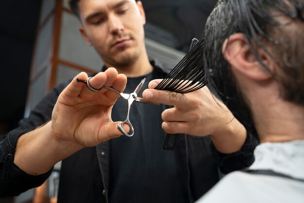 Coiffeur en gros plan à l'aide de ciseaux