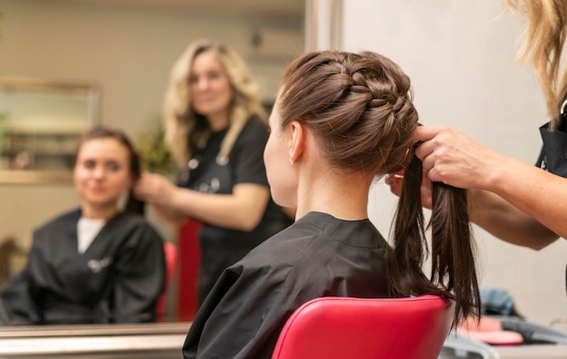 Photo gratuite coiffeur prenant soin des cheveux d'un client à l'intérieur