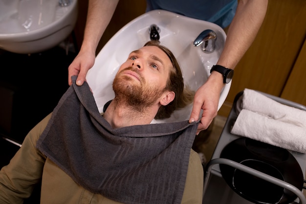 Coiffeur toilettant son client