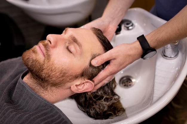 Photo gratuite coiffeur toilettant son client