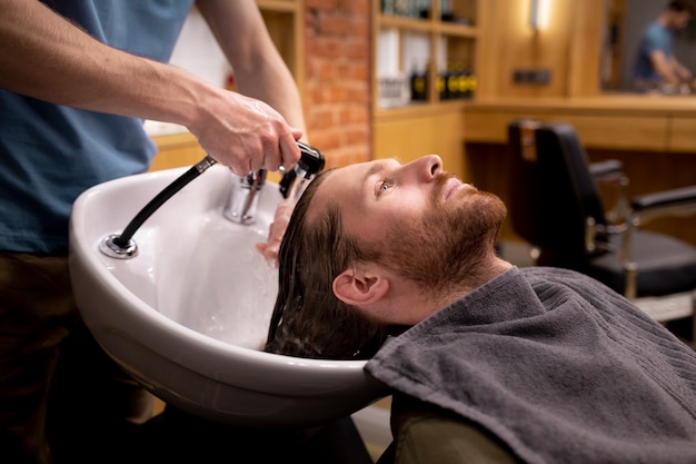 Photo gratuite coiffeur toilettant son client