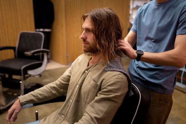 Coiffeur toilettant son client