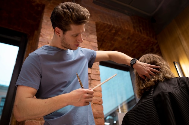 Photo gratuite coiffeur toilettant son client