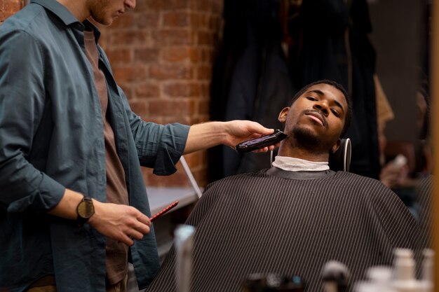 Coiffeur toilettant son client