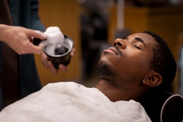 Coiffeur toilettant son client