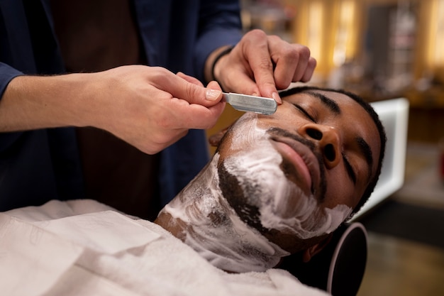 Coiffeur toilettant son client