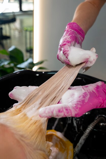 Coiffeur vue de côté laver les cheveux de la femme