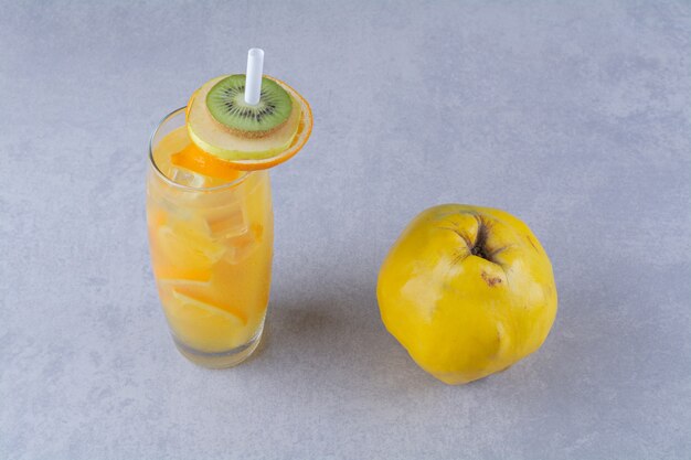 Coing un verre de jus d'orange sur une table en marbre.