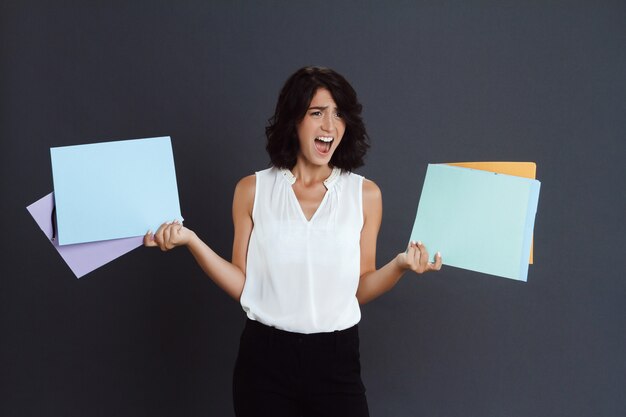 Colère jeune femme tenant des documents en mains